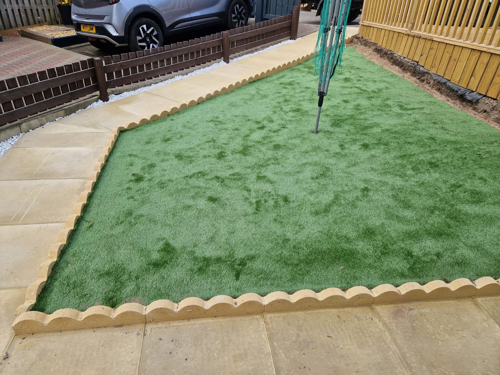 Completed artificial turf lawn installation with clean edging